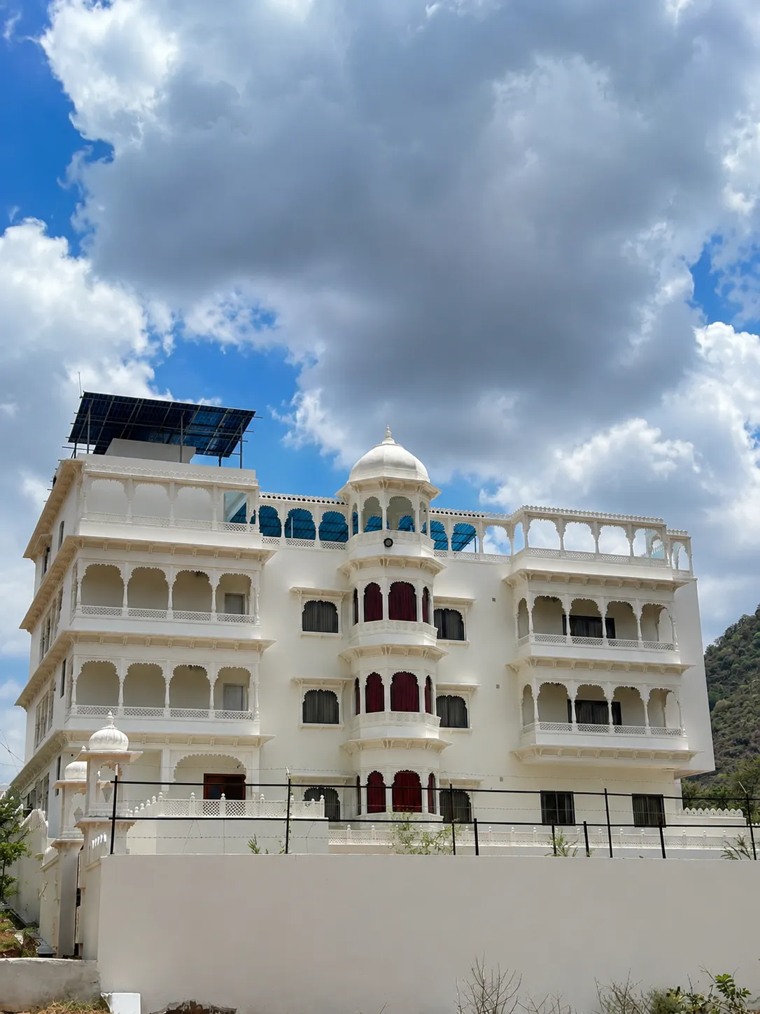 MIJMAAN – The Villa at sunset, warm light in its jharokha balconies, the sun setting behind the Aravalli Hills