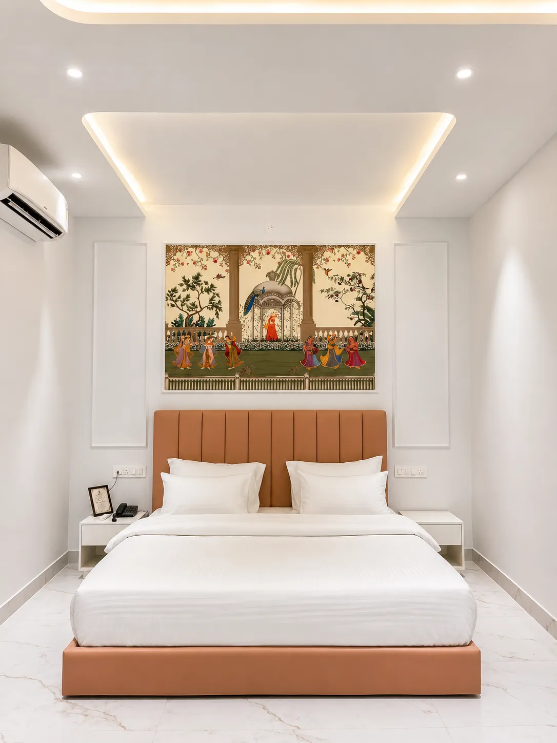 Bedroom with terracotta bed beneath a Rajasthani court-scene mural