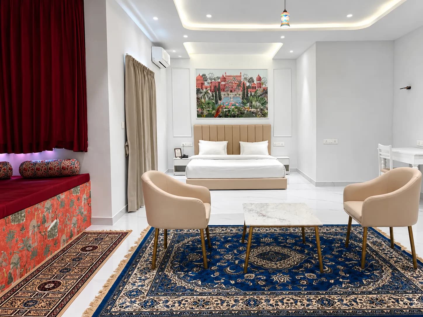 Spacious suite with jharokha daybed, blue Persian rug, and palace mural